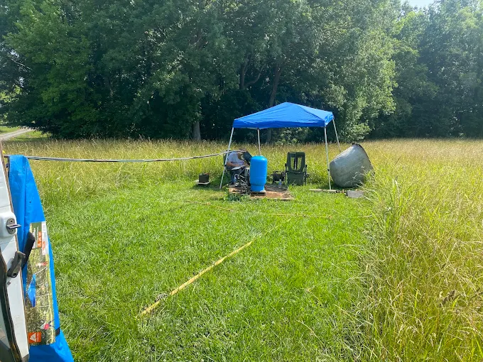 Canopy work station set up in a field with a new pressure tank ready to go in