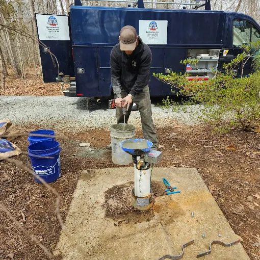 Pulling a submersible pump by hand with the blue Two Guys service truck behind