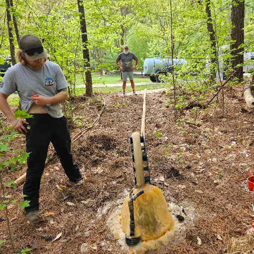 Shane and Joey standing by a long run of iron-caked pipe pulled from a well