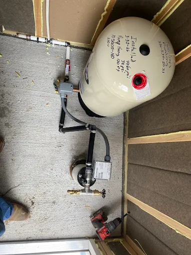 New pressure tank installed in a crawl space with install notes on the tank