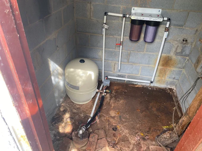 New pressure tank and dual sediment filters plumbed in a block pump house
