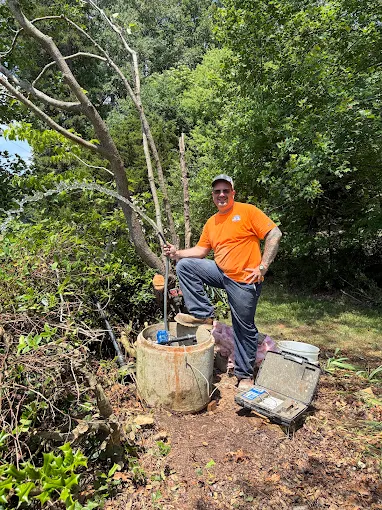 Standing by a concrete well pit with the camera inspection case open
