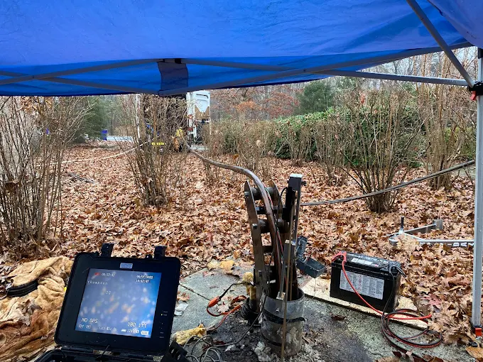 Camera monitor and well seal under a canopy during a deep well inspection at 380 feet