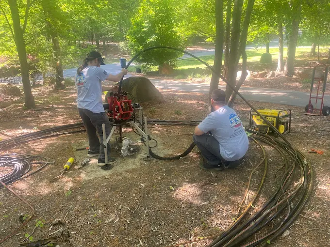 Shane and Joey running well equipment and hose lines on a wooded lot