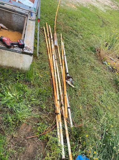Old rusted drop pipe pulled from a well and laid out for replacement