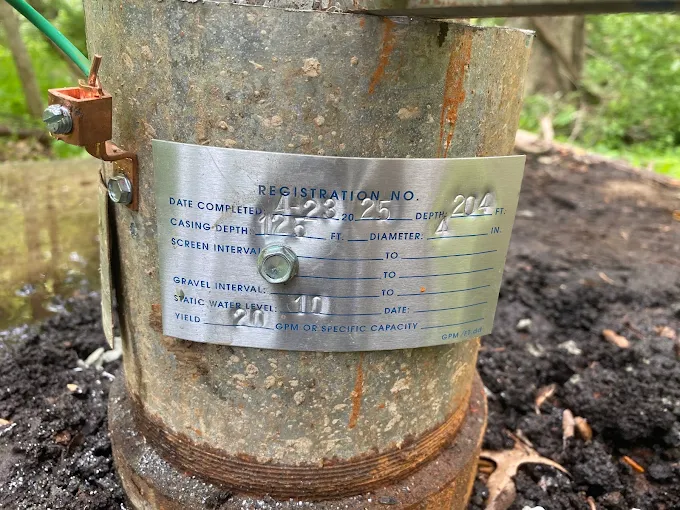 Well registration tag on a casing showing a 204-foot deep, 20 GPM well