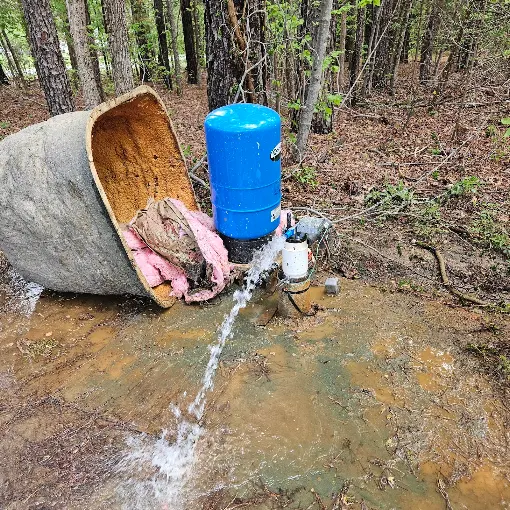 Blue pressure tank flowing at full pressure beside an opened well house