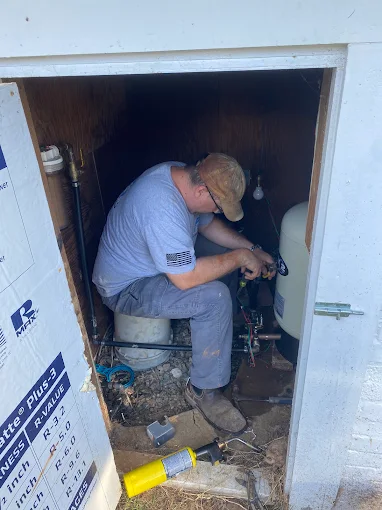 Working inside a well house on a pressure tank and wiring