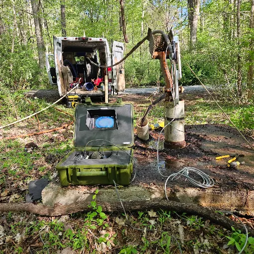 Downhole camera monitor and pump-pull rig set up at a well in the woods