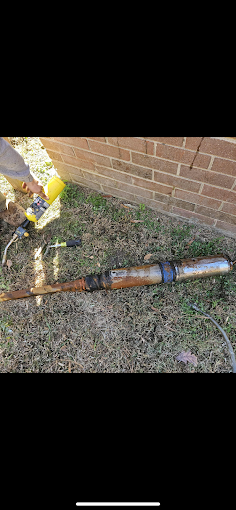 Rusty failed submersible pump pulled and laid out by the house