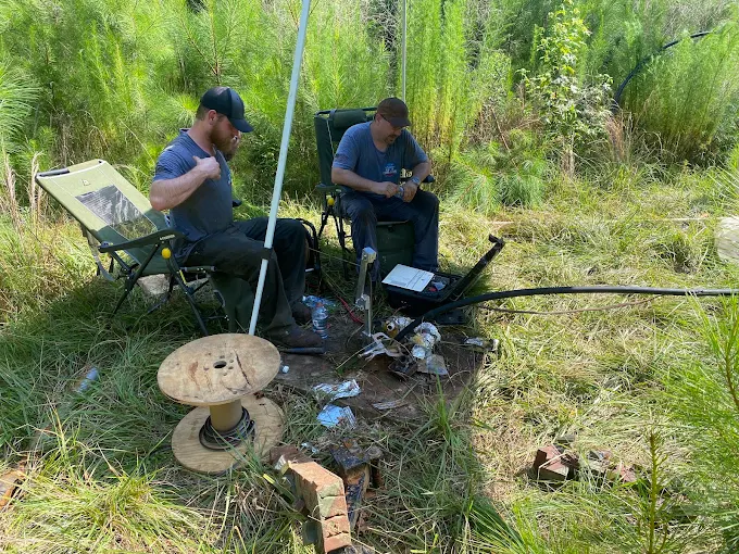 Shane and Joey at a well job in the field with the cable spool and gear laid out