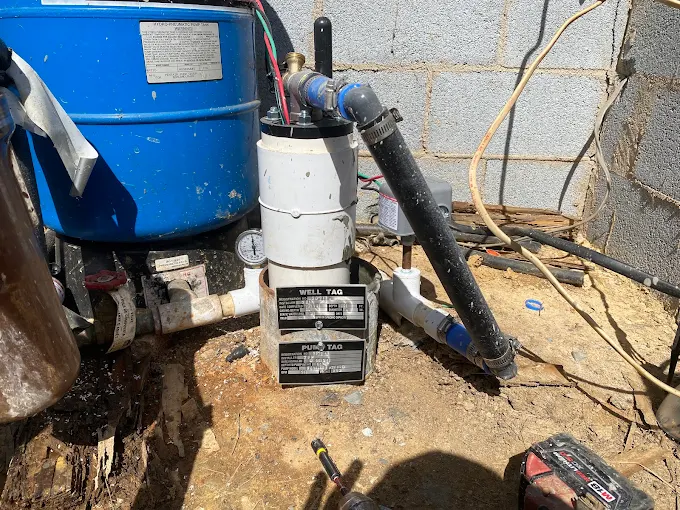 Well tag and pump equipment inside a block well pit mid-service