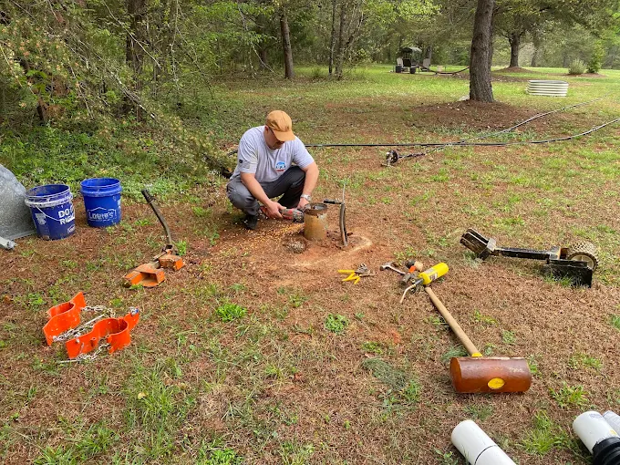 Servicing a well head in the yard with pipe vises, buckets and tools around
