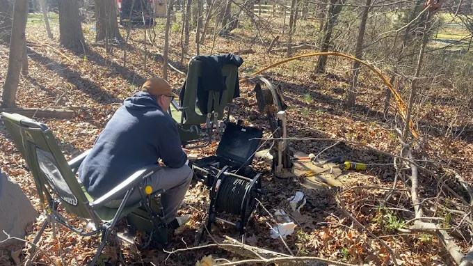 Running a well camera survey at a wooded lot with reel and monitor