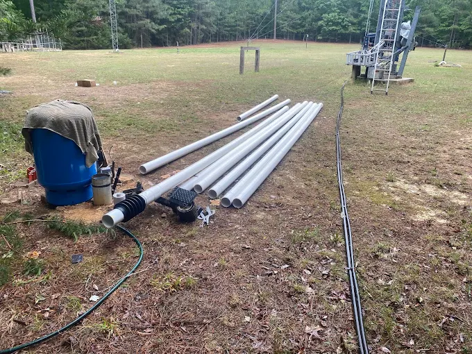 New drop pipe staged at a well near a tower site