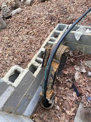 Block well pit opened up with drop pipe and wiring exposed