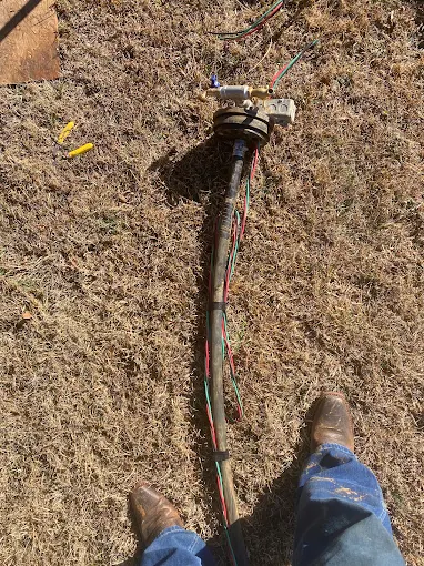 Pulled submersible pump and wire laid out on the grass