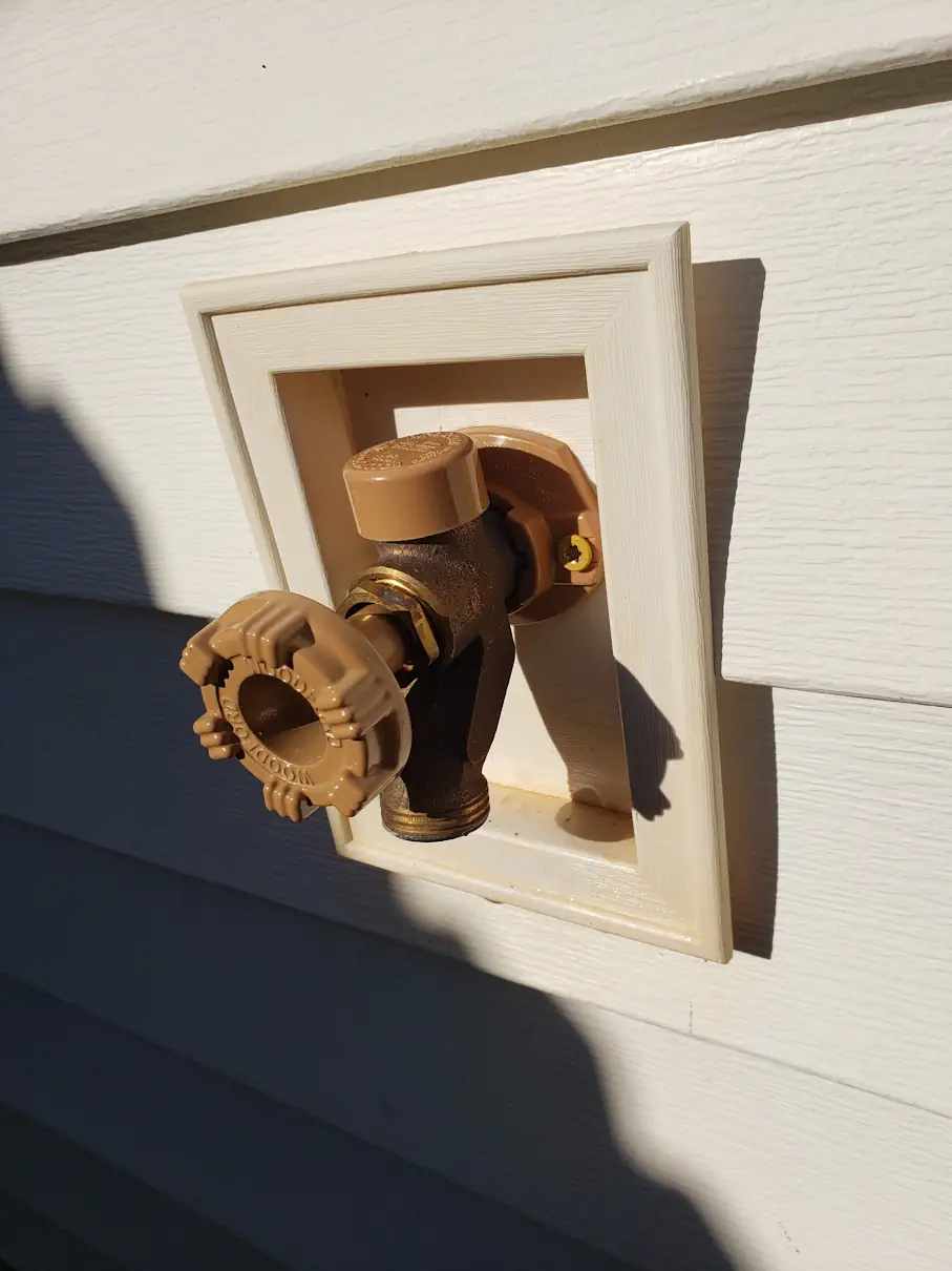 Outdoor spigot and shutoff replaced in a wall box on a home's siding